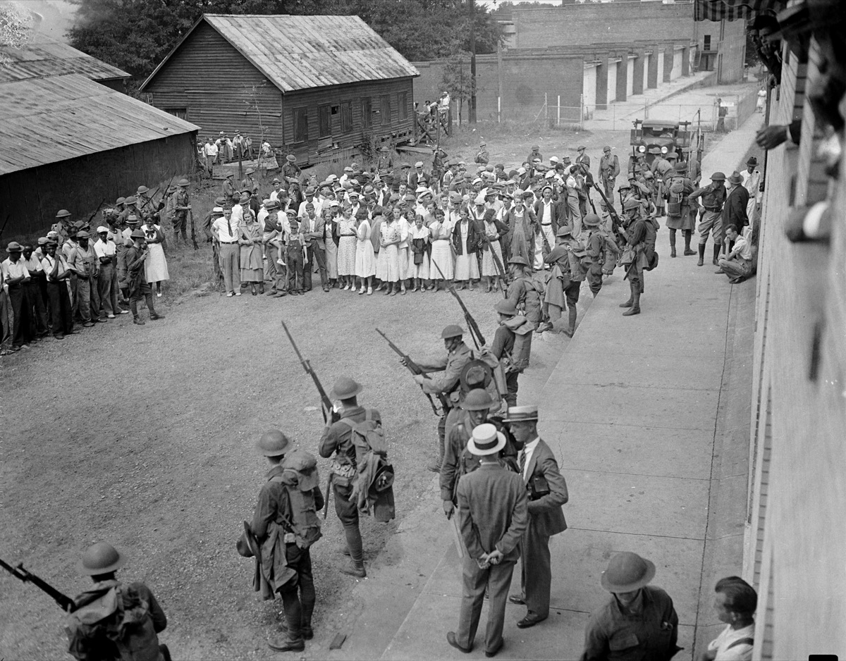 View of members of the Georgia National Guard rounding up strikers gathered outside the Newnan Textile Mill in Newnan, Georgia, 1934